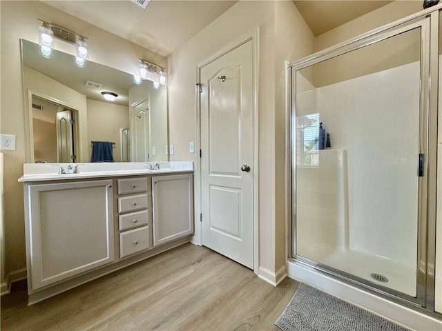 2351 Attewood Dr, Buford, GA 30519 - full bathroom with double vanity, wood finished floors, a shower stall, and baseboards