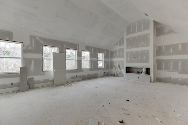 unfurnished living room featuring high vaulted ceiling