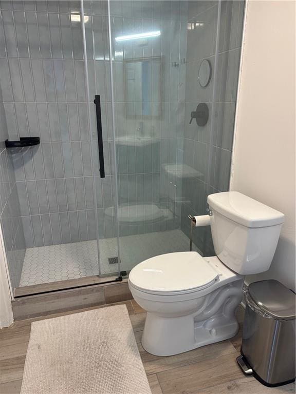 1280 W Peachtree St NW Unit 2409, Atlanta, GA 30309 - bathroom with toilet, a stall shower, and wood finished floors