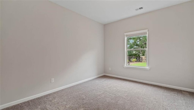 empty room featuring carpet flooring and baseboards