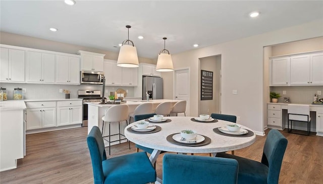 dining space featuring wood finished floors and recessed lighting