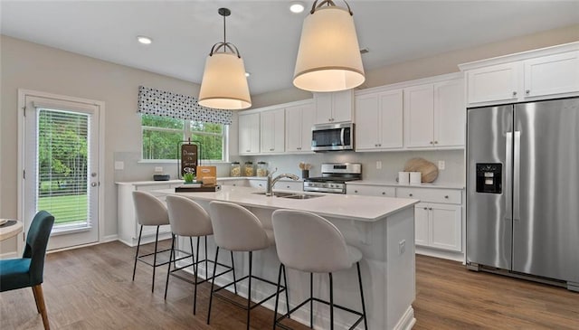 kitchen with appliances with stainless steel finishes, a sink, light countertops, healthy amount of natural light, and recessed lighting