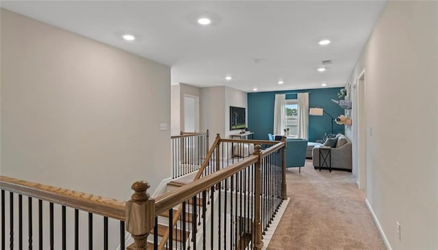 hallway featuring an upstairs landing, light colored carpet, baseboards, and recessed lighting