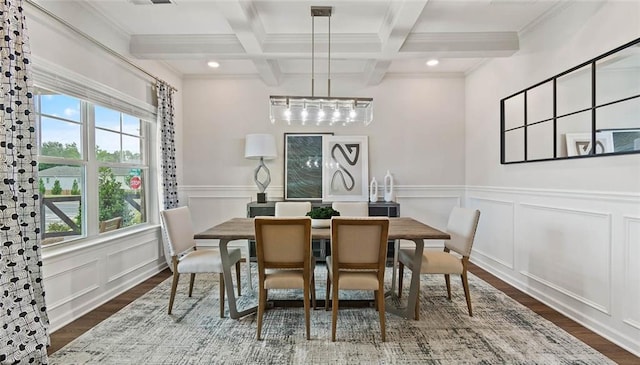 dining area featuring beam ceiling, dark wood-type flooring, coffered ceiling, a decorative wall, and ornamental molding