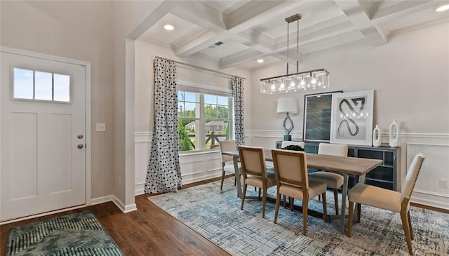 dining space with coffered ceiling, beamed ceiling, dark wood finished floors, a decorative wall, and crown molding