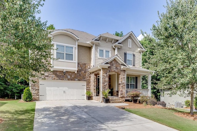 craftsman-style home featuring covered porch, a front yard, and a garage