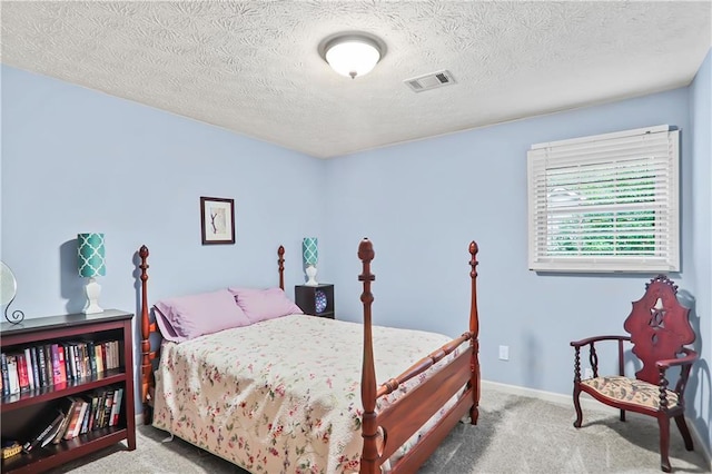 bedroom featuring a textured ceiling, carpet, visible vents, and baseboards