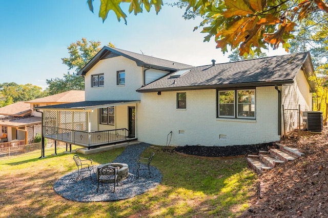 back of house with a lawn, cooling unit, and an outdoor fire pit