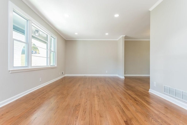 spare room featuring light hardwood / wood-style floors and crown molding