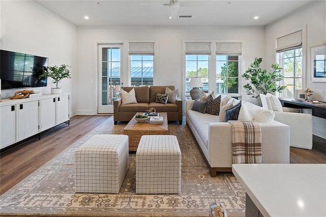 living area with baseboards, visible vents, wood finished floors, and recessed lighting