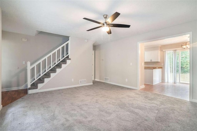 unfurnished living room featuring carpet floors and ceiling fan