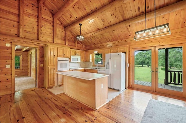 kitchen with a sink, french doors, white appliances, and beam ceiling