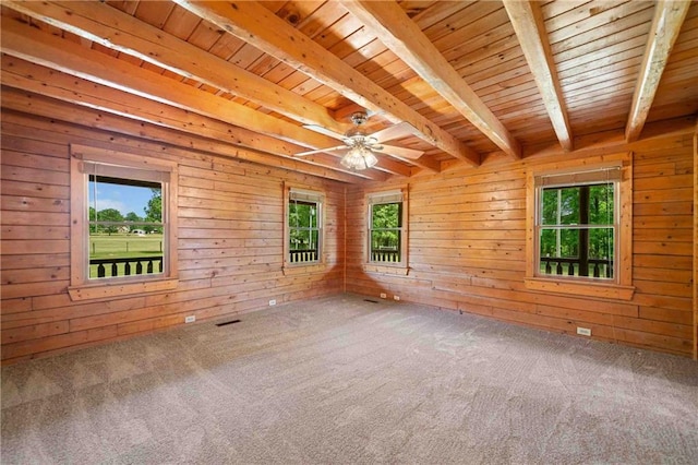 carpeted empty room featuring wood ceiling, a wealth of natural light, and beamed ceiling