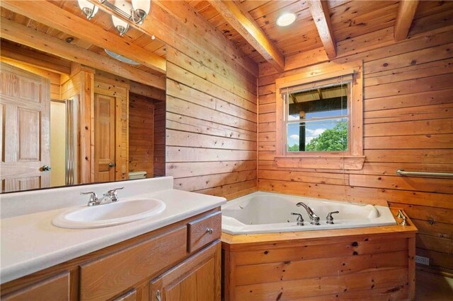 bathroom featuring vanity, wood walls, wooden ceiling, beamed ceiling, and a garden tub