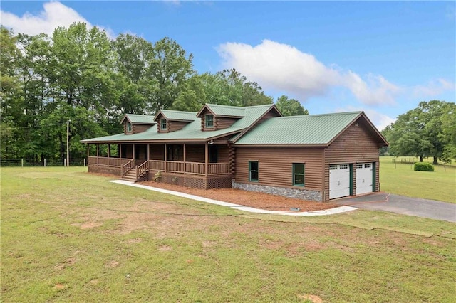 view of front of home featuring fence, a front lawn, a porch, driveway, and metal roof
