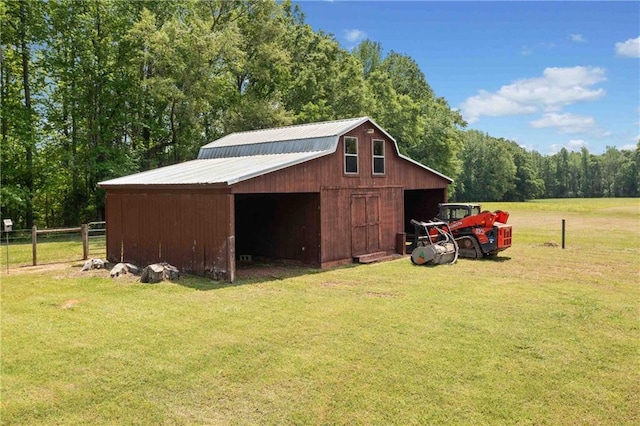 view of outdoor structure featuring a view of trees, fence, and an outbuilding