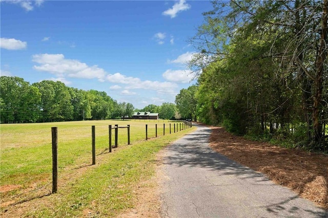 view of street with a wooded view and a rural view