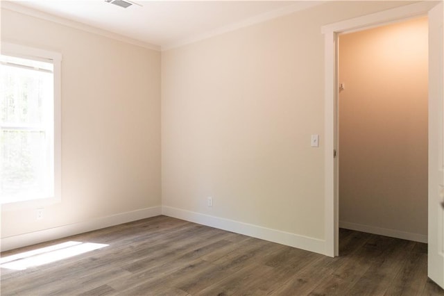 unfurnished room with baseboards, ornamental molding, wood finished floors, and visible vents