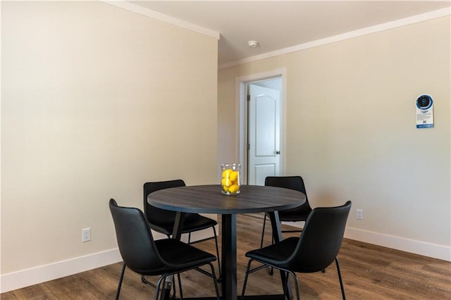 dining space with crown molding, baseboards, and dark wood-type flooring