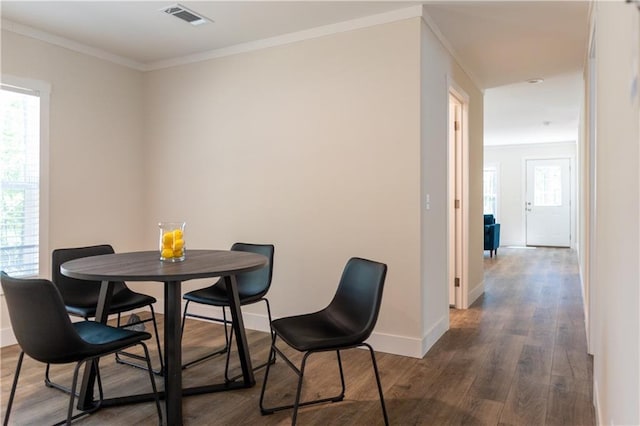 dining space with a healthy amount of sunlight, baseboards, visible vents, and dark wood-type flooring