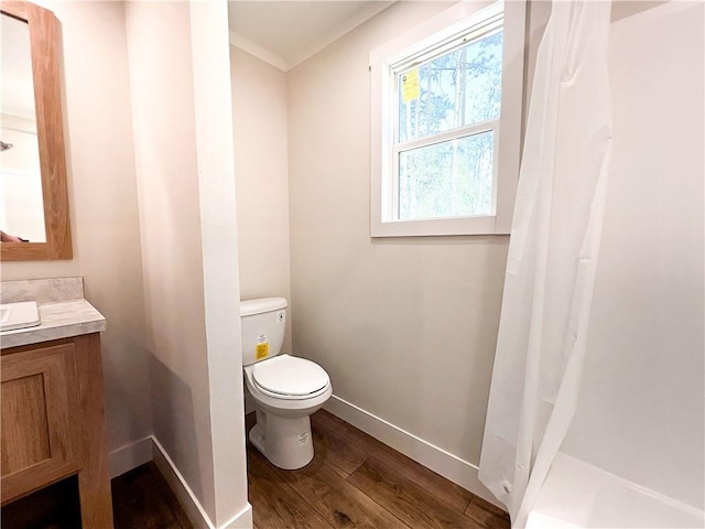 bathroom featuring vanity, curtained shower, wood finished floors, toilet, and baseboards