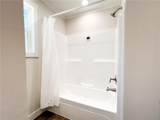 full bath featuring wood finished floors and shower / bath combination with curtain