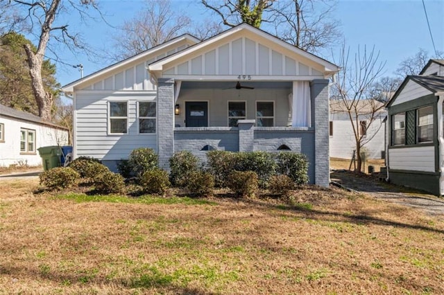 bungalow-style house with ceiling fan, a front lawn, and board and batten siding