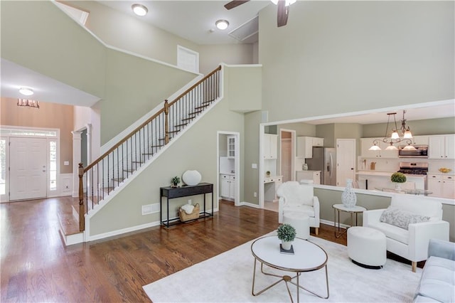 5115 Amberden Hall Dr, Suwanee, GA 30024 - living room featuring a high ceiling, wood finished floors, stairway, a chandelier, and baseboards