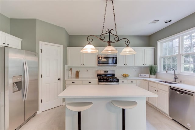 5115 Amberden Hall Dr, Suwanee, GA 30024 - kitchen featuring appliances with stainless steel finishes, a sink, decorative backsplash, light countertops, and a center island