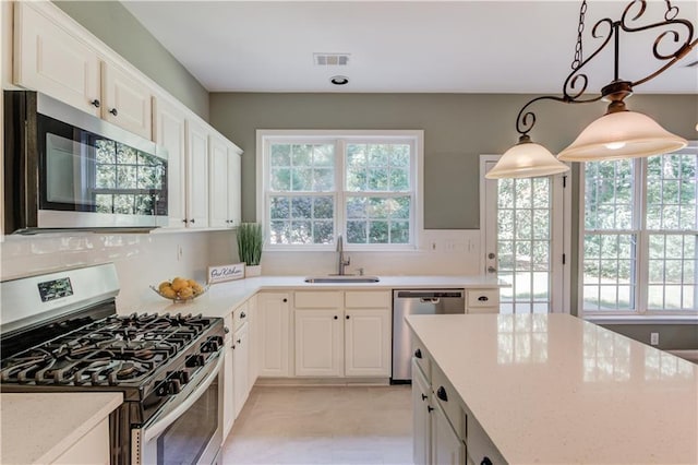 5115 Amberden Hall Dr, Suwanee, GA 30024 - kitchen with stainless steel appliances, a sink, white cabinetry, hanging light fixtures, and light stone countertops