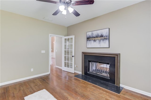 5115 Amberden Hall Dr, Suwanee, GA 30024 - detailed view of a fireplace with flush hearth, wood finished floors, ceiling fan, baseboards, and french doors