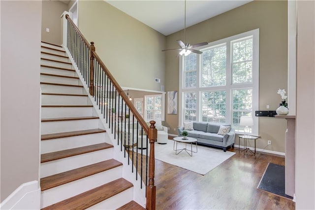 5115 Amberden Hall Dr, Suwanee, GA 30024 - stairs featuring a towering ceiling, wood finished floors, a ceiling fan, and baseboards
