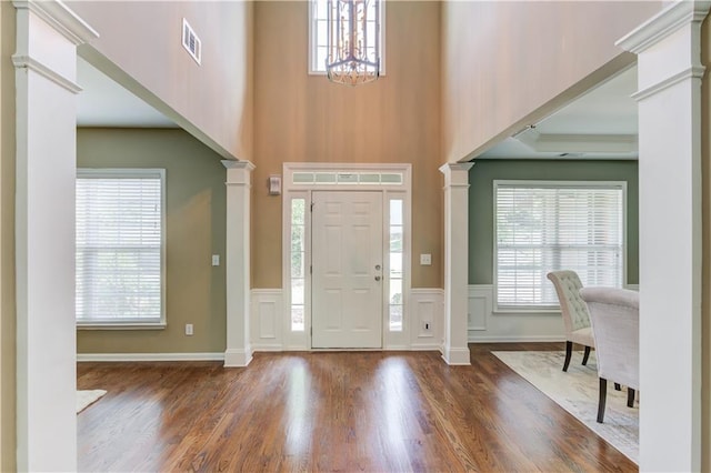 5115 Amberden Hall Dr, Suwanee, GA 30024 - foyer featuring ornate columns, a chandelier, wood finished floors, a high ceiling, and plenty of natural light