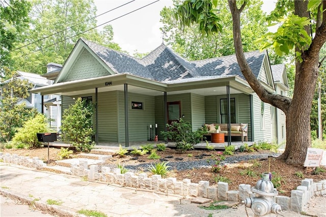 victorian house with a porch and a shingled roof