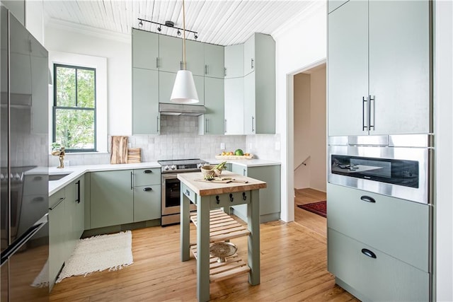 kitchen with light wood-style flooring, electric stove, ornamental molding, freestanding refrigerator, and decorative backsplash