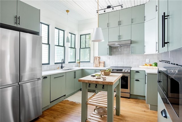 kitchen with stainless steel appliances, under cabinet range hood, and tasteful backsplash