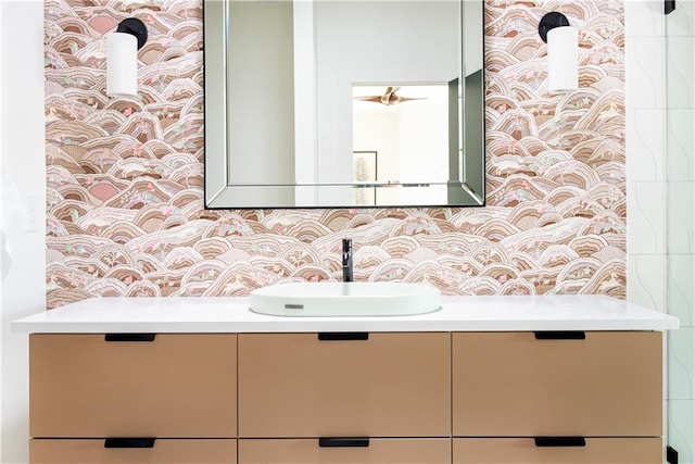 bathroom featuring vanity and wallpapered walls