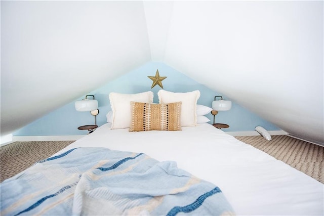 bedroom with vaulted ceiling, carpet flooring, and baseboards