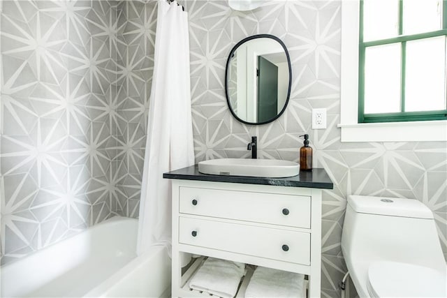 bathroom with toilet, wallpapered walls, shower / bath combo with shower curtain, and vanity