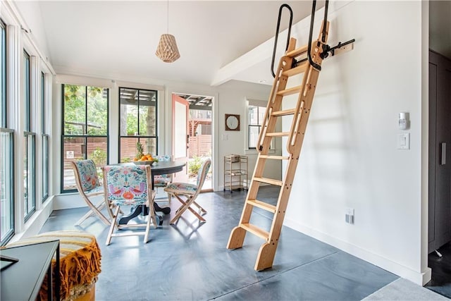 dining room with finished concrete flooring, baseboards, and a wealth of natural light