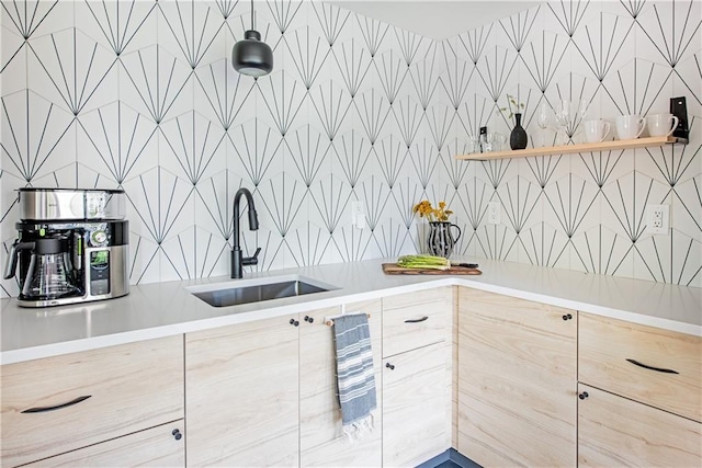 kitchen featuring light countertops, open shelves, and a sink