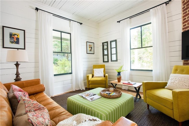 living area with ornamental molding and wood ceiling