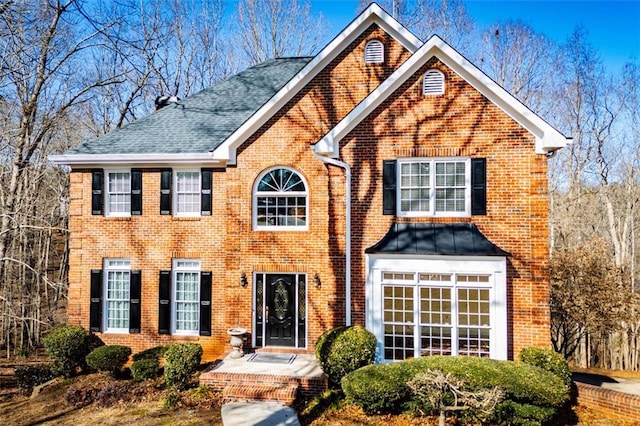 view of front of property featuring brick siding and a shingled roof