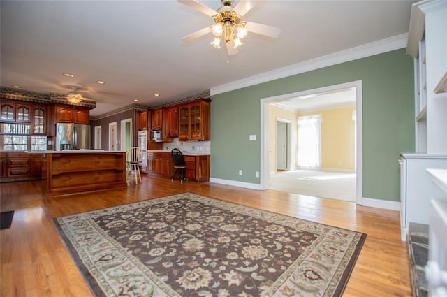 kitchen with stainless steel appliances, baseboards, light wood-style floors, backsplash, and crown molding