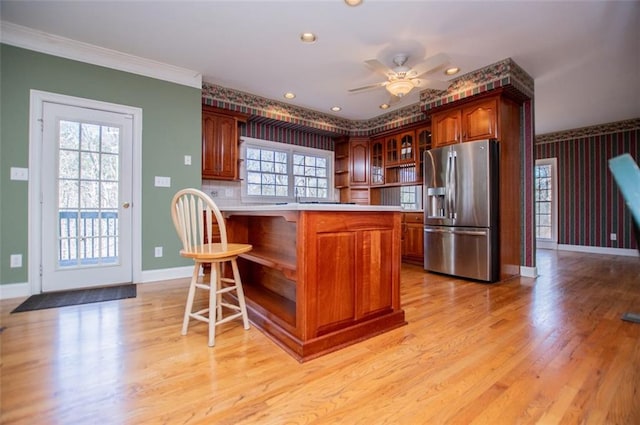 kitchen featuring wallpapered walls, stainless steel fridge with ice dispenser, glass insert cabinets, a kitchen bar, and open shelves