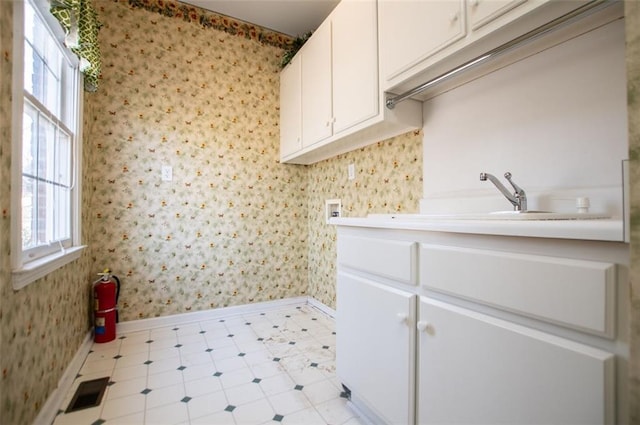 laundry area with wallpapered walls, visible vents, washer hookup, and cabinet space