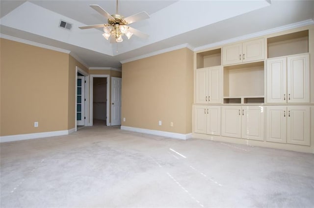 unfurnished bedroom featuring crown molding, a raised ceiling, light colored carpet, visible vents, and baseboards