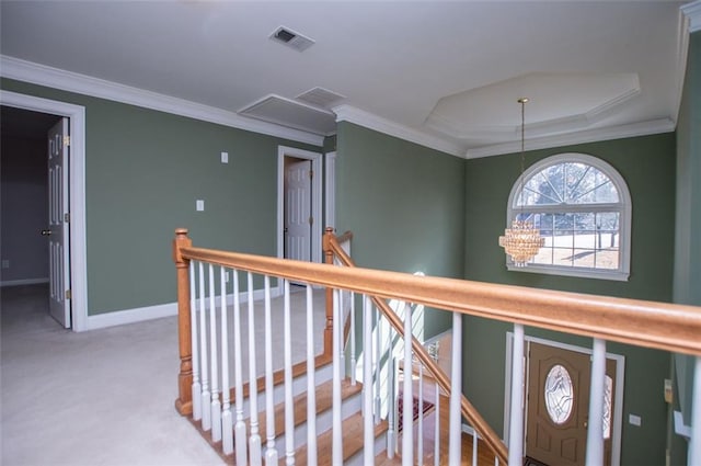 corridor with visible vents, crown molding, and an upstairs landing