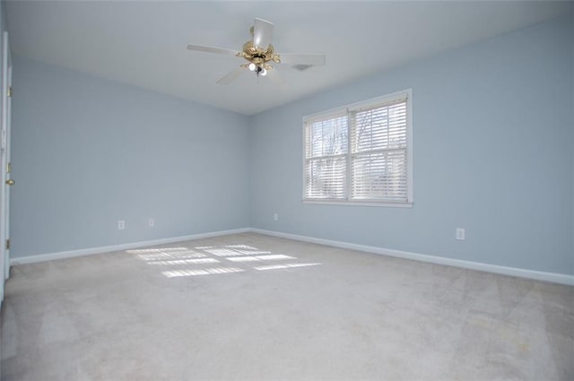 spare room featuring baseboards, ceiling fan, and light colored carpet