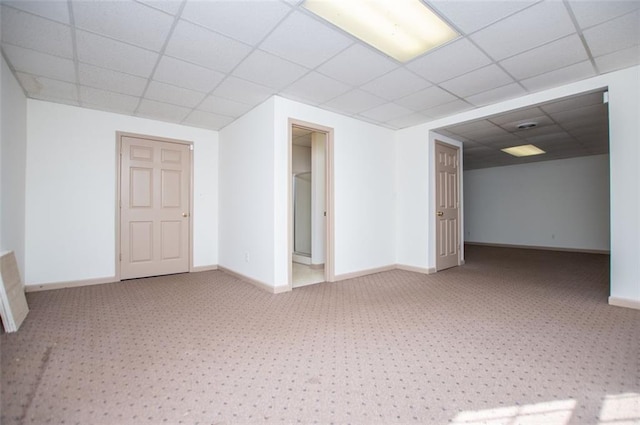 spare room with a paneled ceiling and baseboards